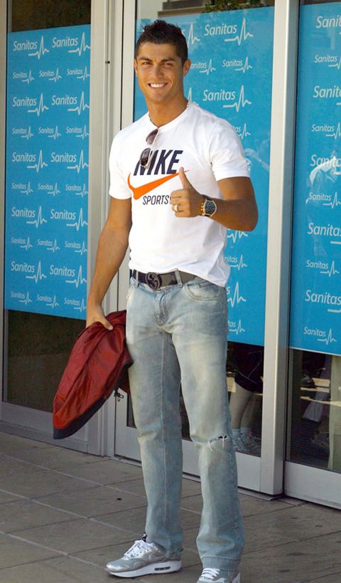 a man standing in front of a store holding a red bag