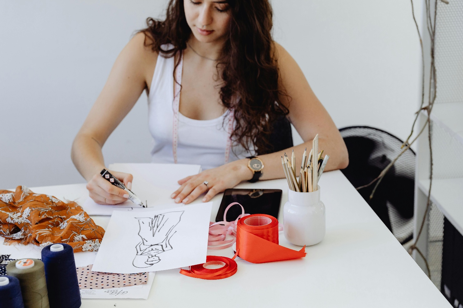 how-to-start-fashion-design-career Figure Fashion designer sketching at a professional studio workspace