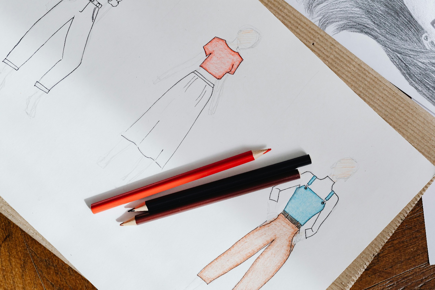 Fashion design portfolio with sketches markers and tools flat lay
