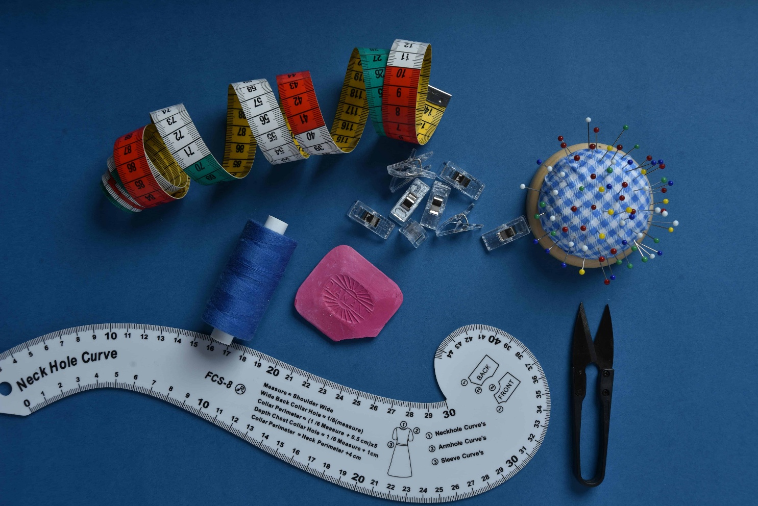 Sewing pattern pieces flat lay with rulers scissors and tailors chalk