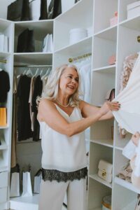 Woman selecting stylish clothes from her wardrobe with confidence