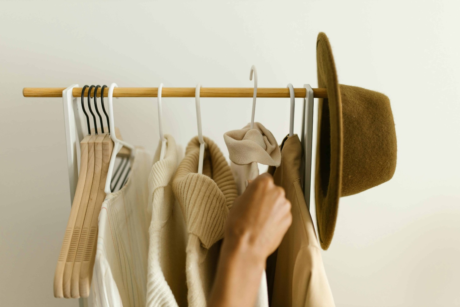 Capsule wardrobe essential pieces in neutral tones in a minimalist organized closet