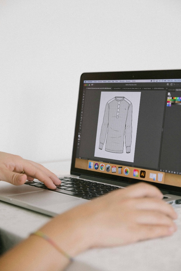 Fashion designer using design software on a computer in a studio workspace