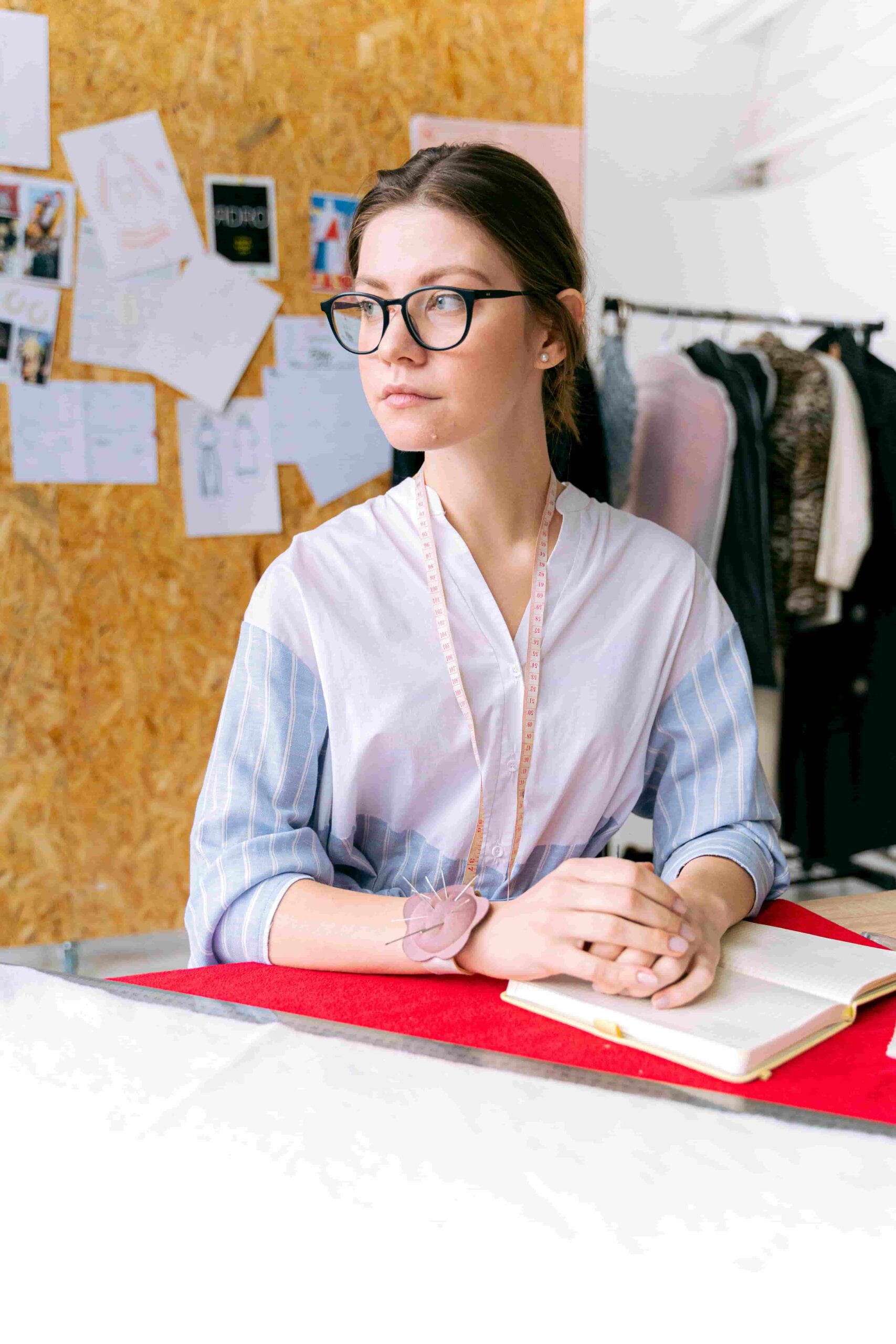 Fashion intern working at a design studio with clothing samples and design workspace
