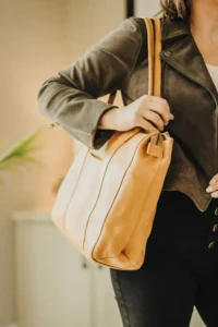 Quality leather tote bag for everyday use in camel color held by woman